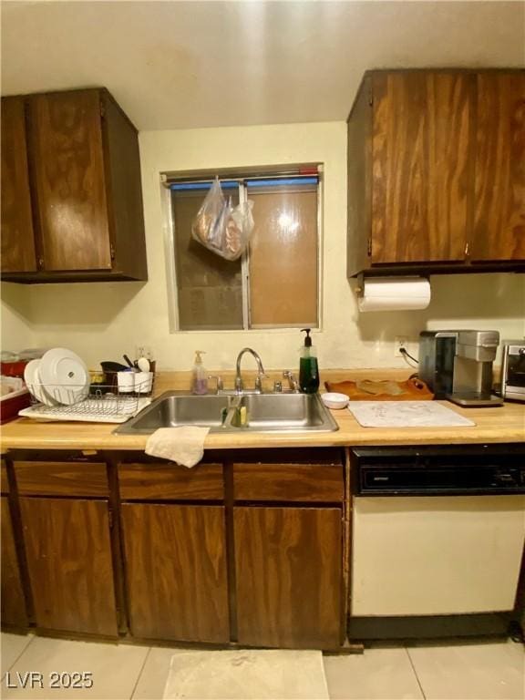 1748 Jupiter Ct Unit C, Las Vegas, NV 89119 - kitchen featuring white dishwasher, a sink, light tile patterned floors, and light countertops