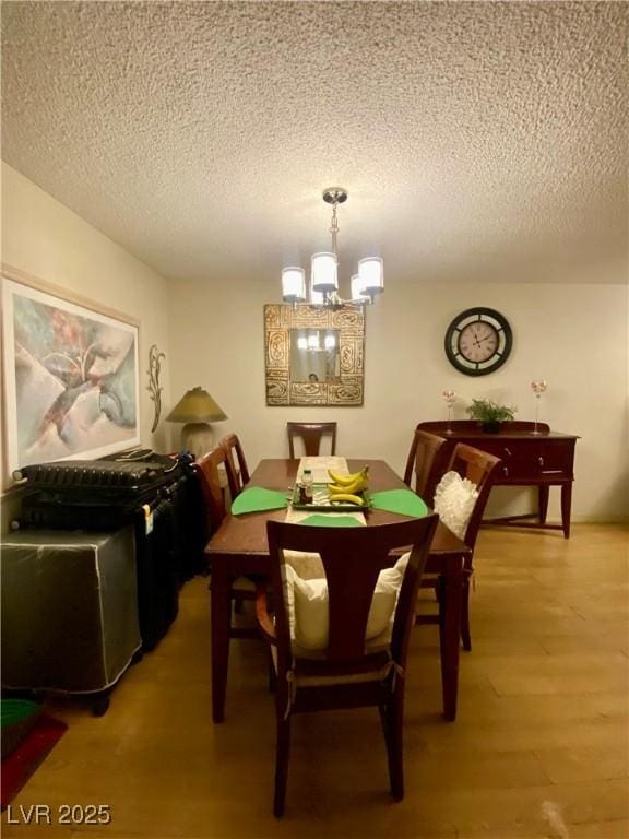 1748 Jupiter Ct Unit C, Las Vegas, NV 89119 - dining area with a textured ceiling, a chandelier, and light wood finished floors