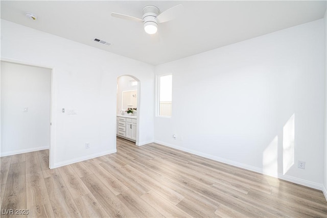 669 Elliot Peak Ave, Las Vegas, NV 89183 - spare room featuring arched walkways, ceiling fan, light wood finished floors, and baseboards