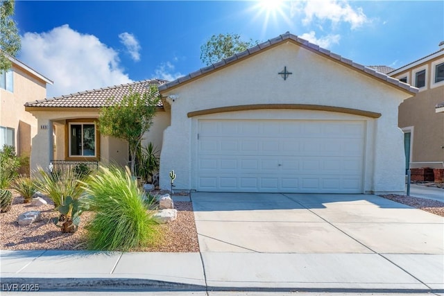 669 Elliot Peak Ave, Las Vegas, NV 89183 - mediterranean / spanish house featuring a tile roof, stucco siding, concrete driveway, and an attached garage