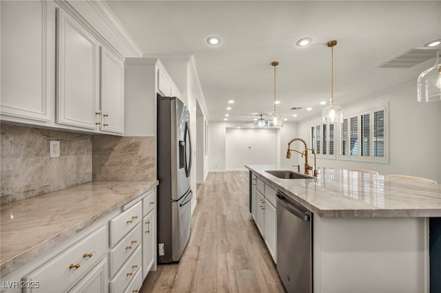 5553 Coral Gate St, Las Vegas, NV 89148 - kitchen featuring stainless steel appliances, a sink, a ceiling fan, light wood-type flooring, and a kitchen island with sink