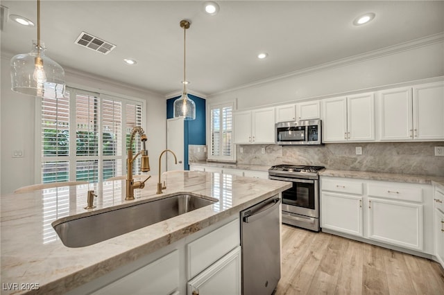 5553 Coral Gate St, Las Vegas, NV 89148 - kitchen with stainless steel appliances, a sink, crown molding, white cabinetry, and backsplash