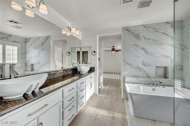 5553 Coral Gate St, Las Vegas, NV 89148 - full bathroom featuring a freestanding tub, double vanity, a ceiling fan, and wood finished floors