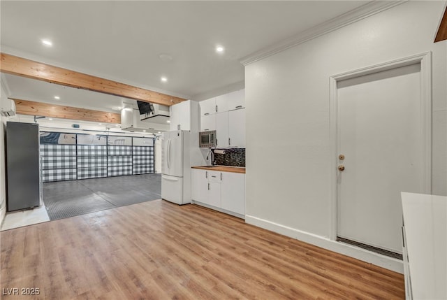 5553 Coral Gate St, Las Vegas, NV 89148 - kitchen with stainless steel microwave, freestanding refrigerator, white cabinets, light wood-type flooring, and recessed lighting