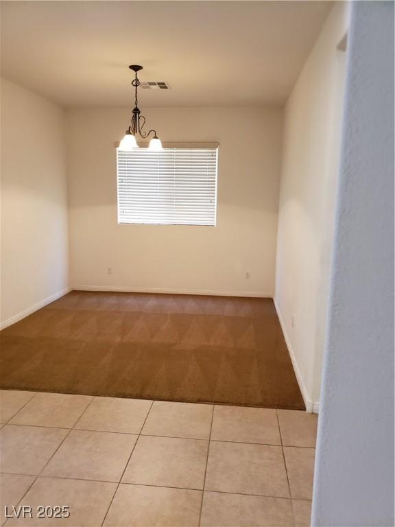 8550 Bright Bush St, Las Vegas, NV 89131 - tiled spare room featuring carpet, baseboards, and a chandelier