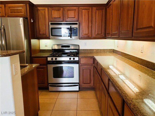 8550 Bright Bush St, Las Vegas, NV 89131 - kitchen featuring stainless steel appliances, dark stone counters, and light tile patterned flooring