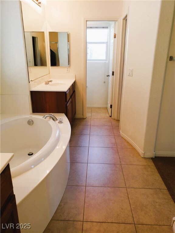 8550 Bright Bush St, Las Vegas, NV 89131 - bathroom with vanity, a garden tub, baseboards, and tile patterned floors