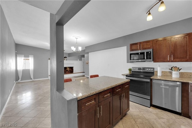 1628 Patricia St, North Las Vegas, NV 89030 - kitchen featuring appliances with stainless steel finishes, light tile patterned floors, and light stone countertops