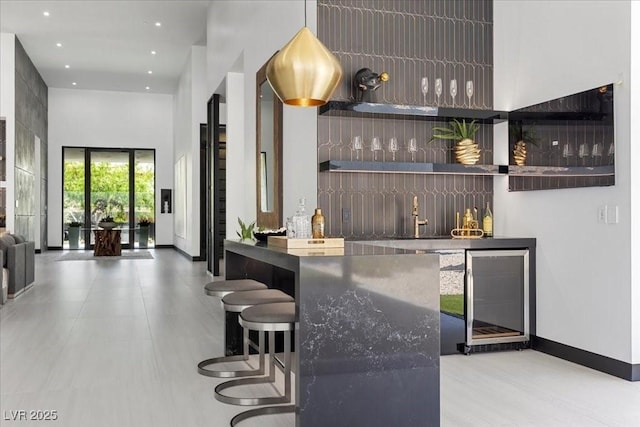 38 Skybird Ct, Las Vegas, NV 89135 - indoor wet bar featuring wine cooler, baseboards, a towering ceiling, and recessed lighting