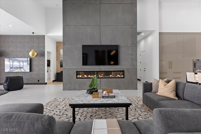 38 Skybird Ct, Las Vegas, NV 89135 - living area with a glass covered fireplace, a high ceiling, and light wood-type flooring