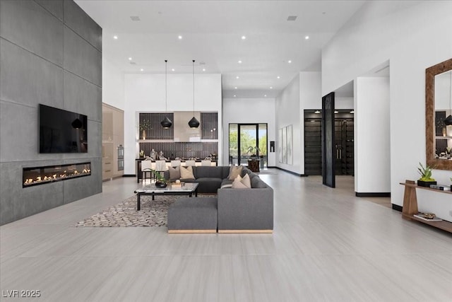 38 Skybird Ct, Las Vegas, NV 89135 - living area featuring a large fireplace, a towering ceiling, and recessed lighting