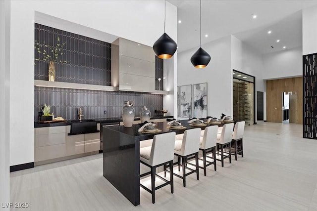 38 Skybird Ct, Las Vegas, NV 89135 - kitchen with a towering ceiling, dark countertops, a sink, modern cabinets, and a kitchen bar