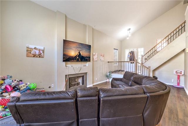 8932 Beach Front Dr, Las Vegas, NV 89117 - living room with wood finished floors, baseboards, a premium fireplace, stairway, and high vaulted ceiling