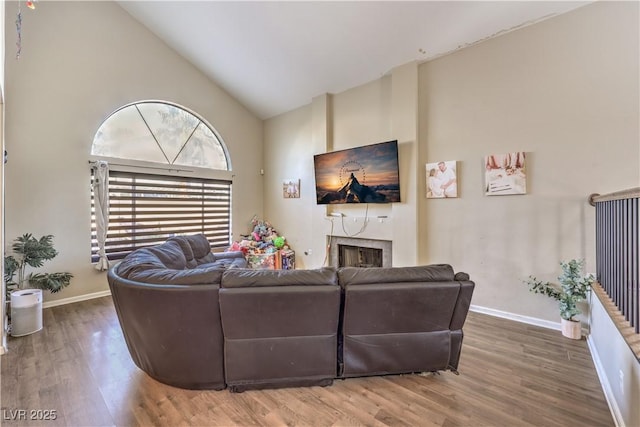8932 Beach Front Dr, Las Vegas, NV 89117 - living room with high vaulted ceiling, wood finished floors, baseboards, and a fireplace