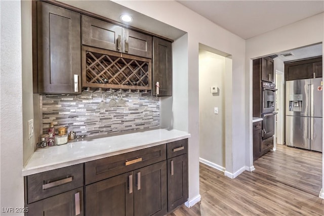 8932 Beach Front Dr, Las Vegas, NV 89117 - indoor dry bar featuring appliances with stainless steel finishes, light wood-style flooring, baseboards, and decorative backsplash