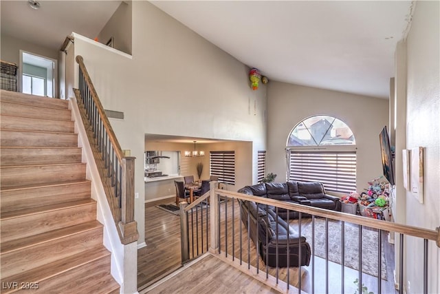 8932 Beach Front Dr, Las Vegas, NV 89117 - staircase with wood finished floors, high vaulted ceiling, and a chandelier