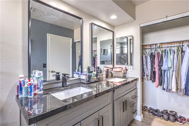 8932 Beach Front Dr, Las Vegas, NV 89117 - full bathroom with double vanity, wood finished floors, baseboards, and a walk in closet