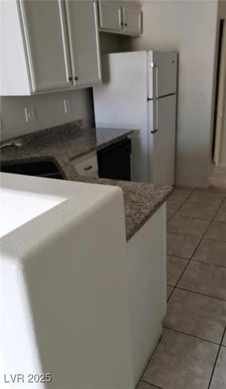 3644 Starlight Evening St, Las Vegas, NV 89129 - kitchen with freestanding refrigerator, light tile patterned floors, dishwasher, and white cabinets