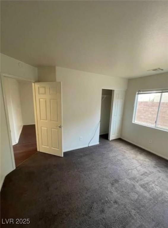 9402 Crimson Sky St, Las Vegas, NV 89178 - unfurnished bedroom featuring dark carpet, a closet, and baseboards