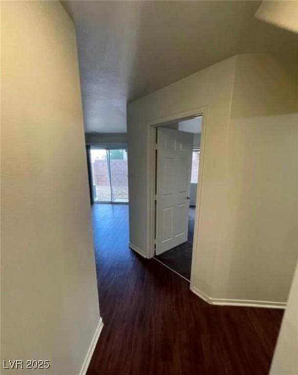 9402 Crimson Sky St, Las Vegas, NV 89178 - hallway featuring baseboards, dark wood-style flooring, and lofted ceiling