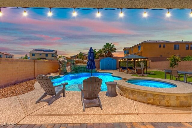 8925 Kenzie Cove St, Las Vegas, NV 89131 - pool at dusk with a gazebo, a fenced backyard, an in-ground hot tub, and a patio