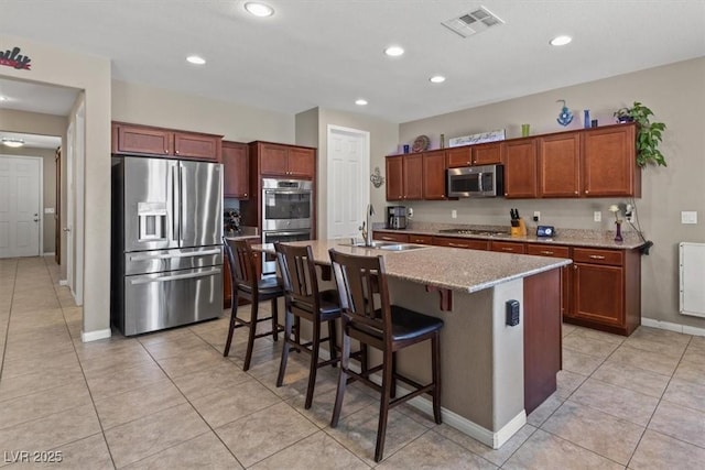 8925 Kenzie Cove St, Las Vegas, NV 89131 - kitchen with stainless steel appliances, a sink, baseboards, light stone countertops, and a breakfast bar area