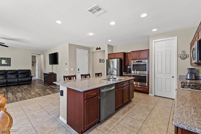 8925 Kenzie Cove St, Las Vegas, NV 89131 - kitchen with appliances with stainless steel finishes, a sink, open floor plan, light tile patterned floors, and a center island with sink