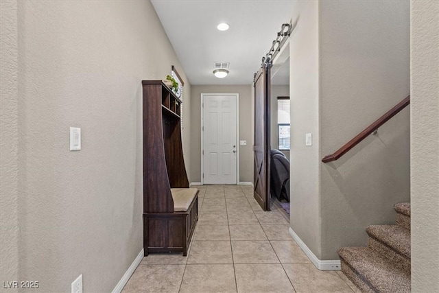 8925 Kenzie Cove St, Las Vegas, NV 89131 - mudroom with light tile patterned flooring, baseboards, a textured wall, and a barn door