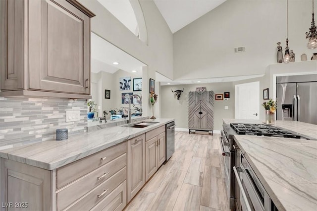 1813 Skyline Dr, Las Vegas, NV 89117 - kitchen featuring stainless steel appliances, a sink, decorative backsplash, light stone countertops, and high vaulted ceiling