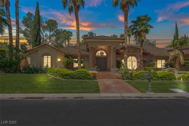 1813 Skyline Dr, Las Vegas, NV 89117 - mediterranean / spanish house featuring a tile roof, stucco siding, and a front lawn