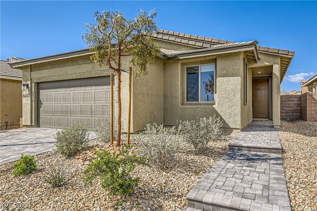 6607 Summershade St, North Las Vegas, NV 89086 - view of front of property with a garage, stucco siding, and driveway