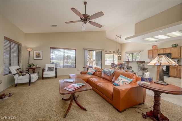 1441 Palm Dr, Laughlin, NV 89029 - living room featuring healthy amount of natural light, light carpet, ceiling fan, high vaulted ceiling, and a chandelier