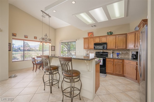 1441 Palm Dr, Laughlin, NV 89029 - kitchen featuring black appliances, light tile patterned floors, a kitchen bar, decorative backsplash, and a center island