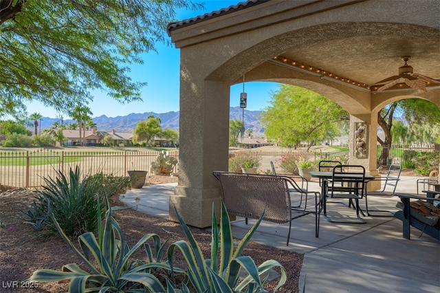 1441 Palm Dr, Laughlin, NV 89029 - fenced backyard featuring a ceiling fan, a patio area, a mountain view, and outdoor dining space