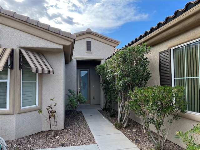 5049 Alfingo St, Las Vegas, NV 89135 - view of exterior entry featuring stucco siding and a tiled roof