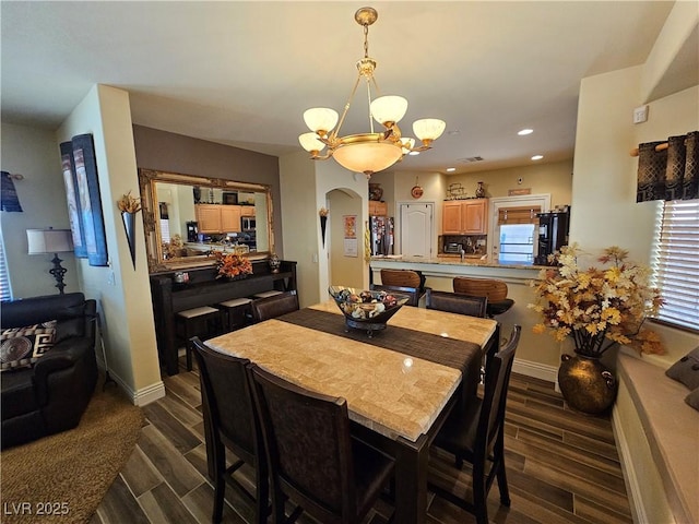 2691 Benton Cove St, Laughlin, NV 89029 - dining space featuring a chandelier, arched walkways, wood tiled floors, recessed lighting, and baseboards