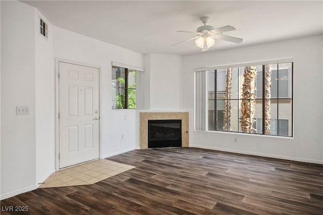 7143 S Durango Dr Unit 202, Las Vegas, NV 89113 - unfurnished living room with wood finished floors, a ceiling fan, a tiled fireplace, and baseboards