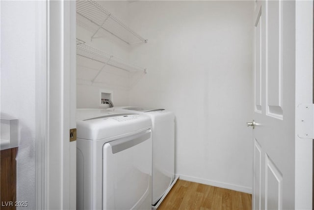 7143 S Durango Dr Unit 202, Las Vegas, NV 89113 - laundry area with washing machine and dryer, light wood finished floors, and baseboards