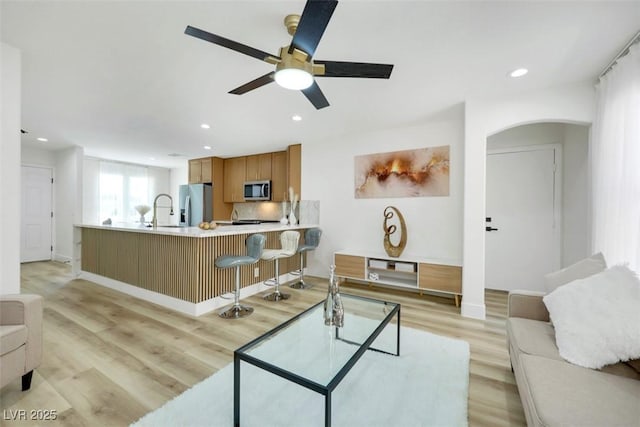 9078 Hilverson Ave, Las Vegas, NV 89148 - living area featuring arched walkways, a ceiling fan, light wood-style flooring, recessed lighting, and baseboards