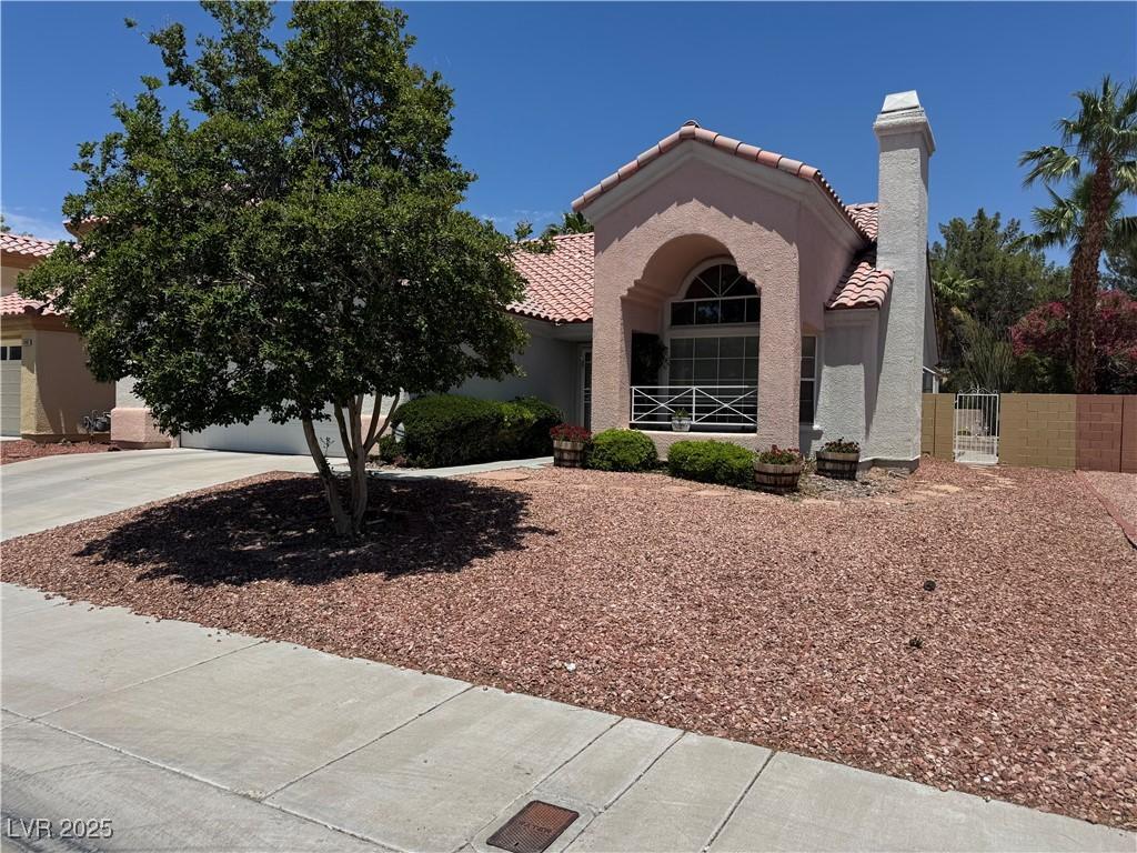 2904 Channel Bay Dr, Las Vegas, NV 89128 - mediterranean / spanish home with a tiled roof, stucco siding, a gate, driveway, and a chimney