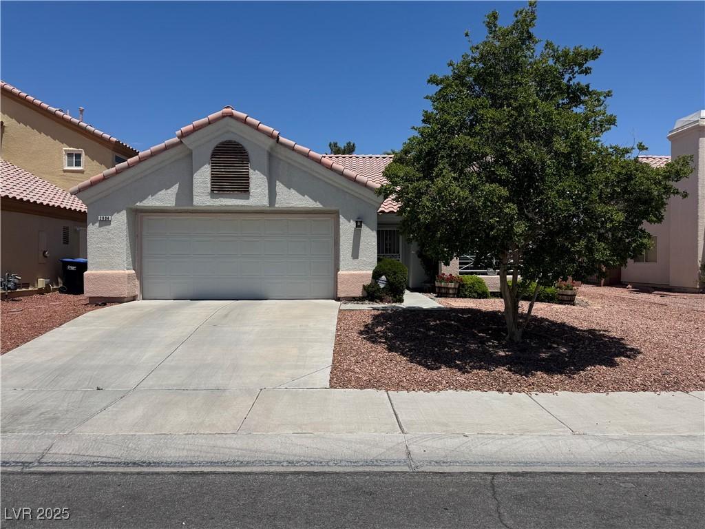 2904 Channel Bay Dr, Las Vegas, NV 89128 - view of front of house with a garage, driveway, stucco siding, and a tile roof