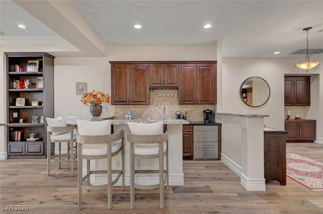 748 Puerto Real Ct, Las Vegas, NV 89138 - kitchen with backsplash, a kitchen breakfast bar, light wood-type flooring, pendant lighting, and recessed lighting