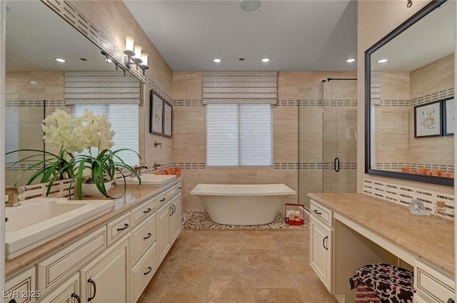 748 Puerto Real Ct, Las Vegas, NV 89138 - bathroom featuring a soaking tub, a shower stall, double vanity, tile walls, and recessed lighting