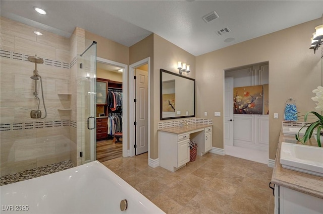 748 Puerto Real Ct, Las Vegas, NV 89138 - full bathroom featuring vanity, a shower stall, a soaking tub, baseboards, and a walk in closet