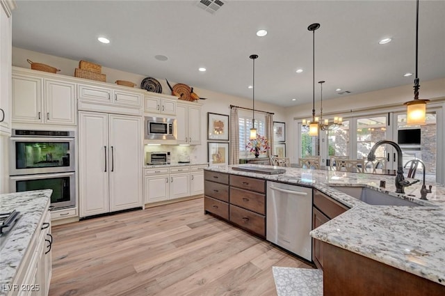 748 Puerto Real Ct, Las Vegas, NV 89138 - kitchen with built in appliances, a sink, light wood finished floors, pendant lighting, and recessed lighting