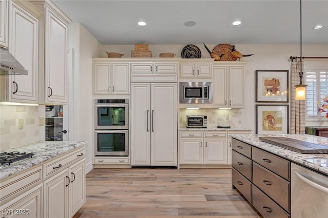 748 Puerto Real Ct, Las Vegas, NV 89138 - kitchen featuring built in appliances, light wood-style floors, backsplash, decorative light fixtures, and light stone counters