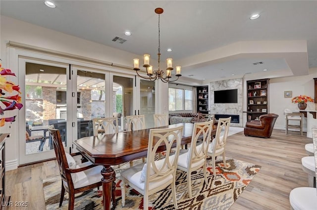 748 Puerto Real Ct, Las Vegas, NV 89138 - dining area featuring a fireplace, a chandelier, light wood finished floors, recessed lighting, and a tray ceiling