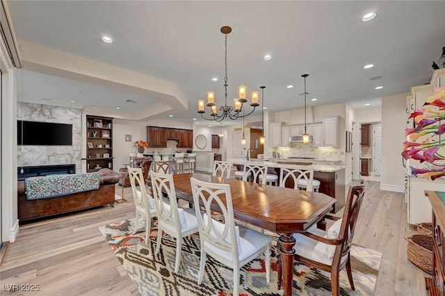 748 Puerto Real Ct, Las Vegas, NV 89138 - dining area featuring light wood-style floors, recessed lighting, a chandelier, a high end fireplace, and baseboards