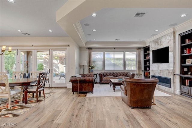 748 Puerto Real Ct, Las Vegas, NV 89138 - living room with ornamental molding, light wood-style flooring, plenty of natural light, french doors, and a premium fireplace