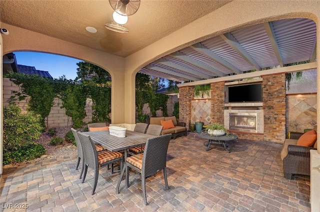 748 Puerto Real Ct, Las Vegas, NV 89138 - view of patio / terrace featuring a warm lit fireplace and outdoor dining area